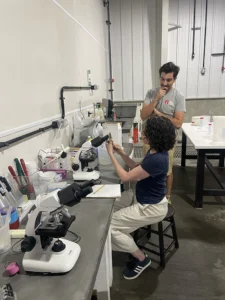 Michael Acquafredda and NJ RMI team looking in a microscope.